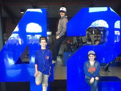 Carmen Matarazzo, Gaten Matarazzo, and Sabrina Matarazzo are posing with a huge blue colored 42 number shape.